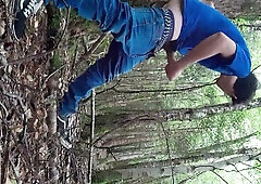 Young man jacks off openly in a sunlit forest clearing