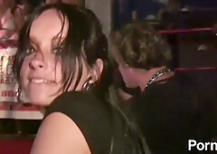 Two women share a steamy moment under the club lights as one lifts her skirt