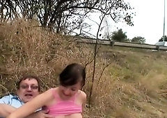 Busty brunette fingers her pussy and blows a cock outside