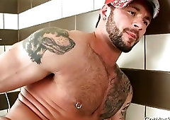 Pierced hunk stuffing his anus with dildo