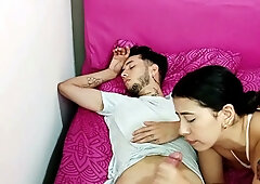 Dark-haired Latina woman shares intimate moment with resting man on pink bed