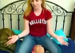 Blonde in red shirt dominates bound redhead in black leather during foot fetish session