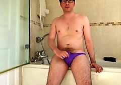 Horny European twink in a purple cock pouch jerks off in the locker room