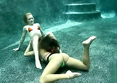 Brunette and blonde lovers share steamy underwater kisses before moving to the carpet