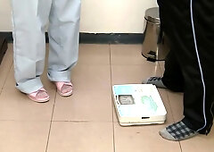 Young Asian nurse performs intimate exam on male patient in clinic