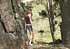 Tanned long haired bitch leans over the tree to piss outdoors
