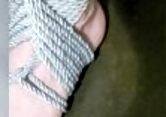 Transgender foot with painted toes in a shibari sandal