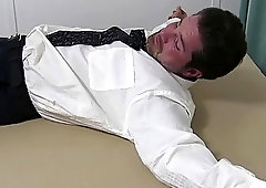 Tied up businessman in a suit tickled all over his feet