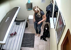Blonde MILF prepares for a solarium session in her private hallway