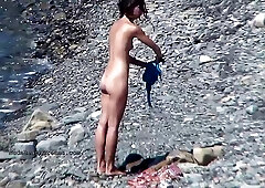 Many naked people are enjoying on the beach in the middle of a sunny day