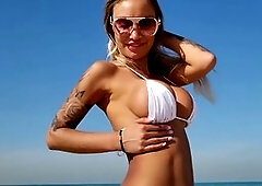 Monika Fox shows off her big boobs in a white bikini on the beach