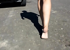 Woman In Short Shorts Walks Around Barefoot Outside On The Pavement