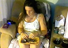 Breasty beauty in pink brassiere and pants smokin' and playing movie games
