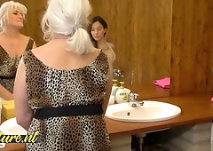 Mature tattooed lesbian couple share intimate moments on sofa and in bathroom