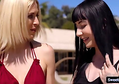 Gothic woman in black stockings embraces her blonde lover outdoors