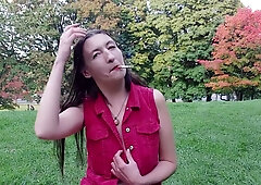 Gypsy Dolores bares it all in a red shirt while smoking in an autumn park
