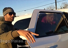 Curvy blonde in pink jacket meets bearded man by white pickup on suburban road
