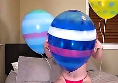 Playing young milf having fun with balloons on the bed