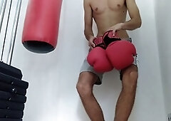Slim twink with a massive hard-on pounds the punching bag and cums on the gloves