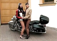 2 wild harlots in fishnet ebony underware are engaged in lesbo games on a motorcycle