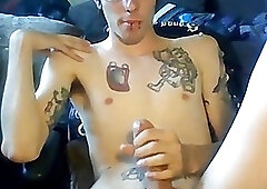 Inked young man with glasses passionately tugs on his cock