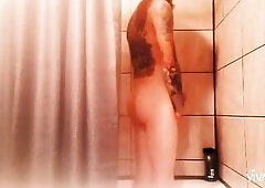 Tattooed man stroking in shower