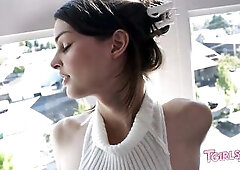 Brunette hair trans model in a white micro bikini and arm warmers teases by the window, exposing herself previous to kneeling and masturbating on the 